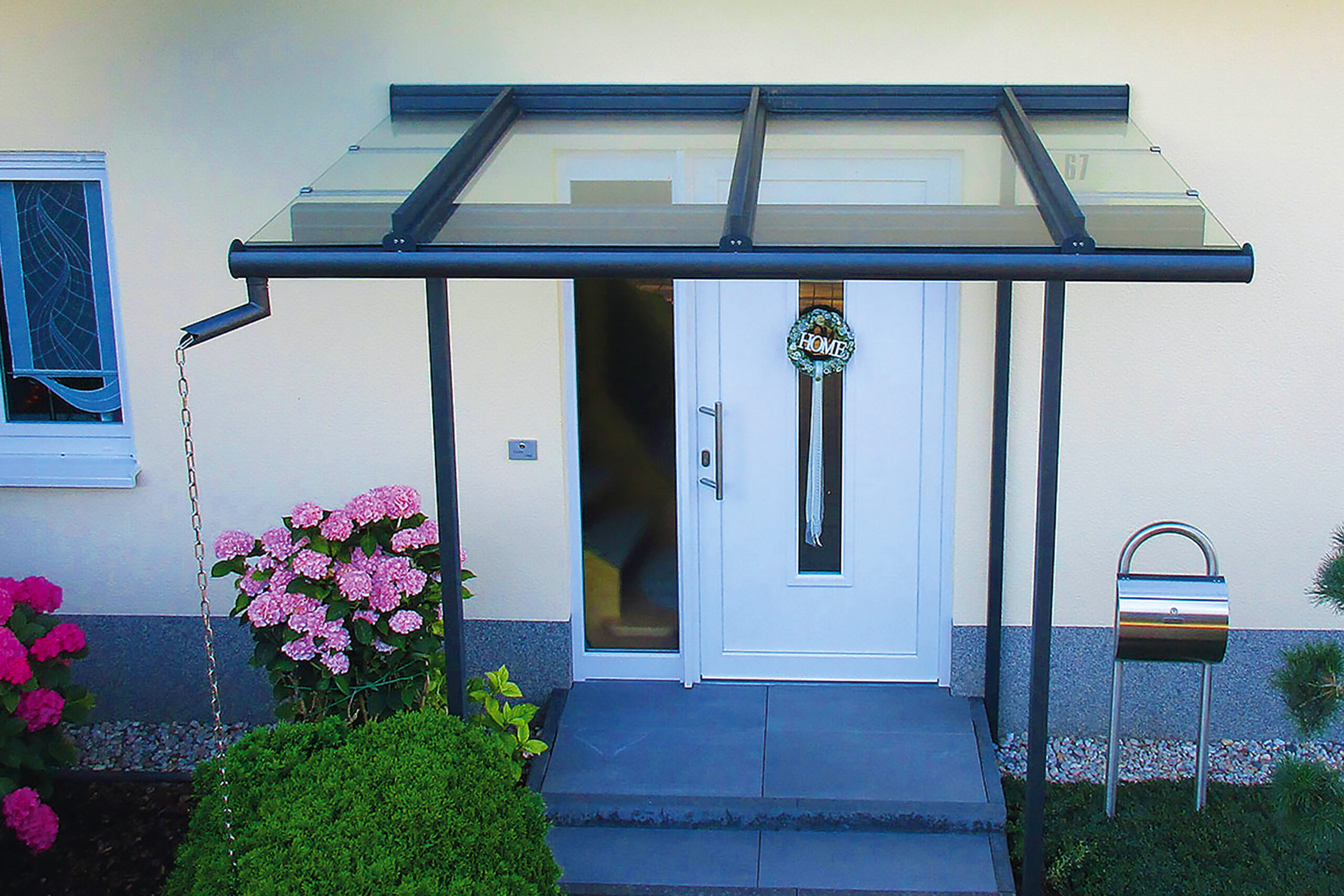 ExtremeLine AquaTube Fallrohrsystem an einer modernen Terrassenüberdachung bei starkem Regen. Das integrierte Entwässerungssystem leitet Regenwasser kontrolliert und zuverlässig über die Stützen ab und schützt Terrasse, Fassade und Außenbereich vor Staunässe.