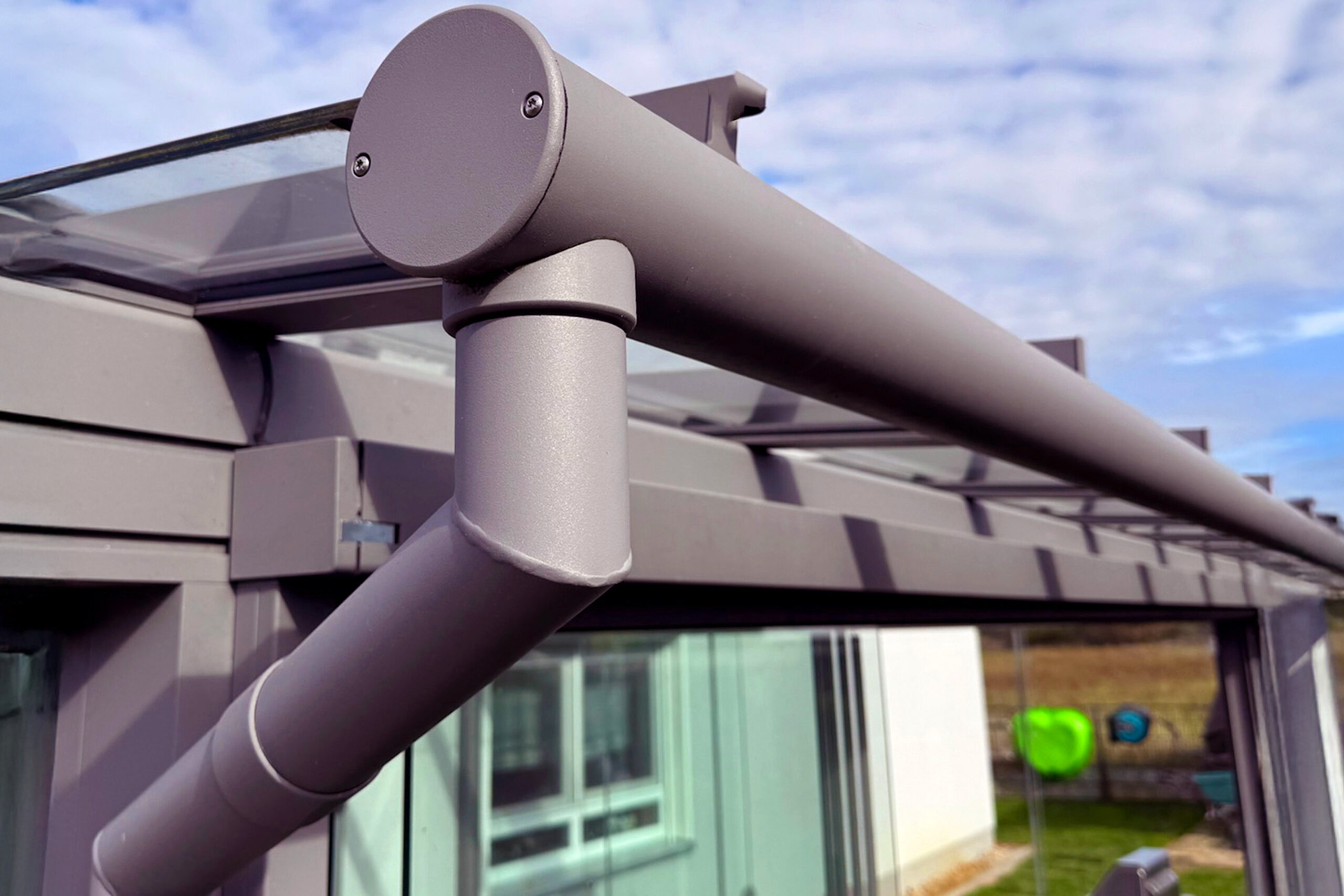 ExtremeLine AquaTube Fallrohrsystem an einer modernen Terrassenüberdachung bei starkem Regen. Das integrierte Entwässerungssystem leitet Regenwasser kontrolliert und zuverlässig über die Stützen ab und schützt Terrasse, Fassade und Außenbereich vor Staunässe.